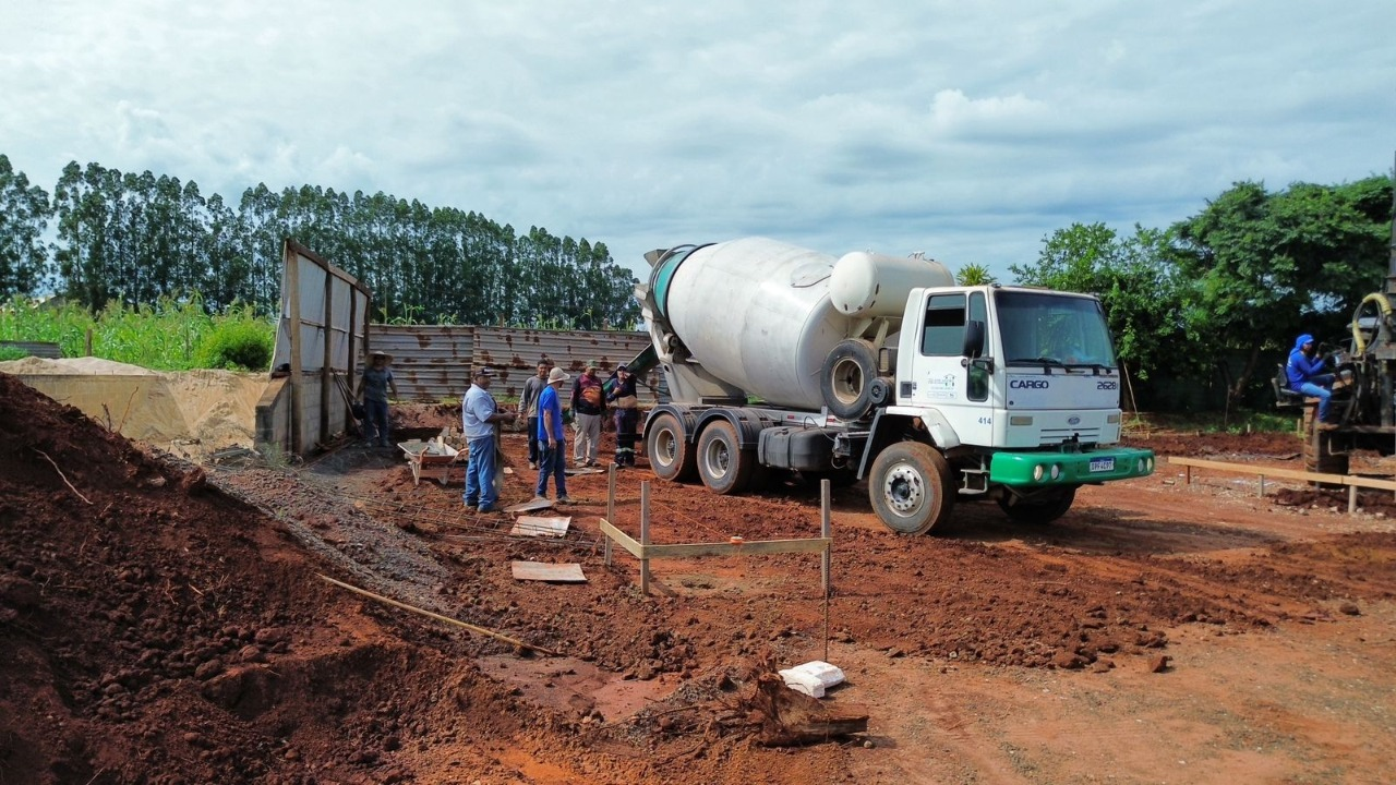 Caminhão betoneira e trabalhadores em um canteiro de obras